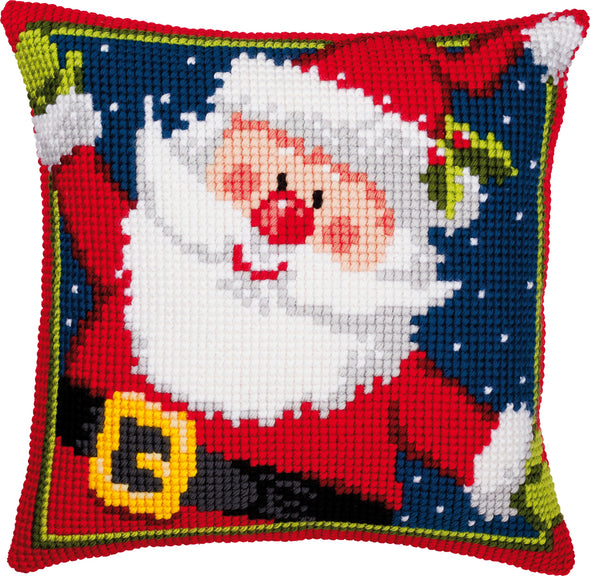 Cross-stitched pillow with a festive design of Santa Claus on a blue background.