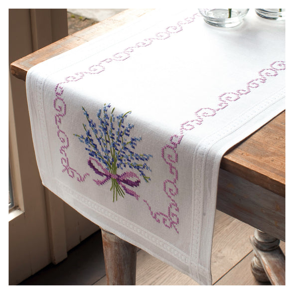 Embroidered table runner with lavender design on a wooden table.