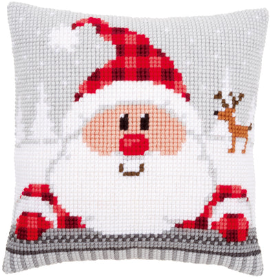 Cross-stitched Santa Claus design on a pillow with a reindeer in the background.