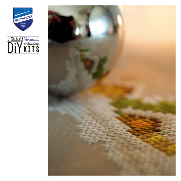 Close-up of embroidered fabric with a Vervaco logo in the corner