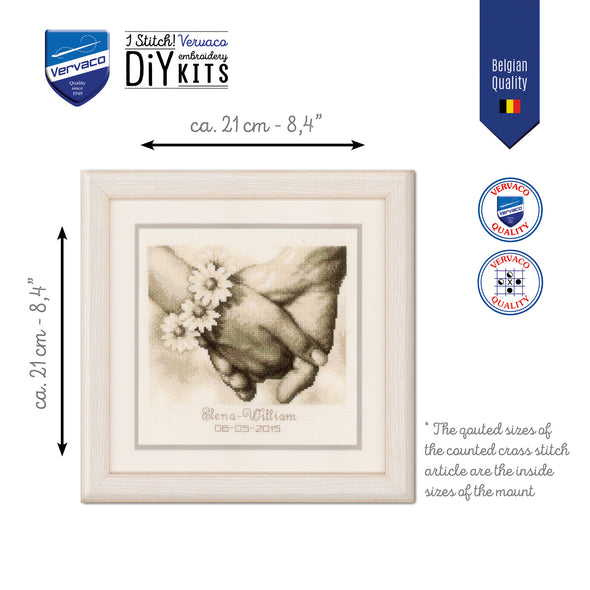 Framed cross-stitch kit with hands holding a flower, dimensions indicated, and Vervaco branding.