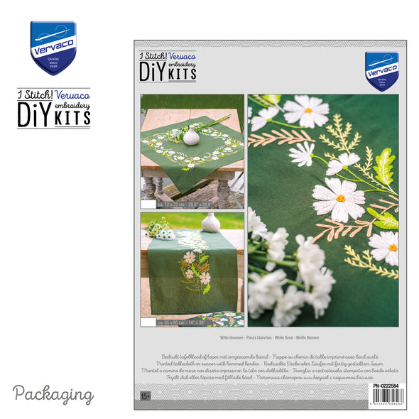 Vervaco embroidery DIY kit packaging with floral design on a green tablecloth.