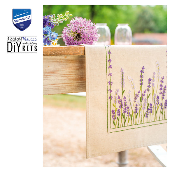 Embroidered towel with lavender design on a table outdoors, featuring Vervaco branding.